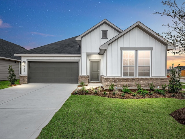 view of front of house featuring brick siding, a yard, concrete driveway, board and batten siding, and a garage