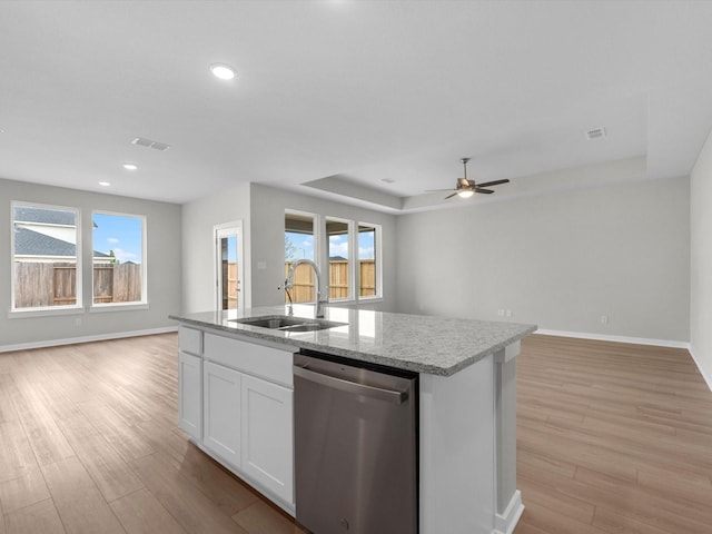 kitchen featuring open floor plan, dishwasher, and a sink