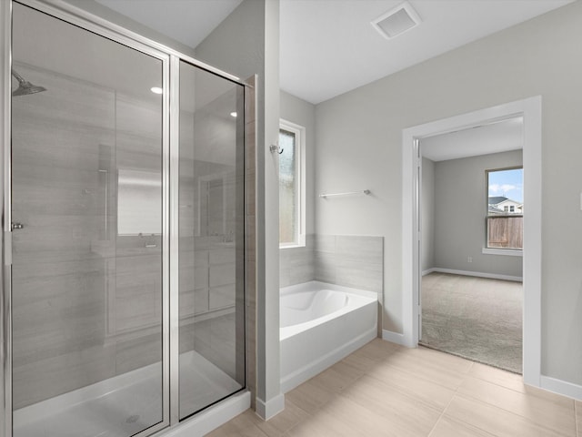 full bathroom with a stall shower, baseboards, visible vents, and a bath