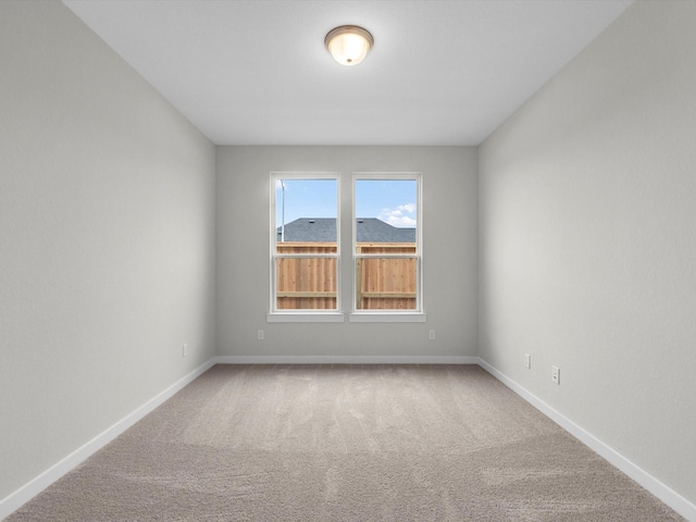 carpeted empty room with baseboards