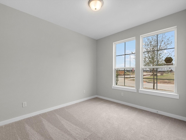 unfurnished room featuring carpet flooring and baseboards