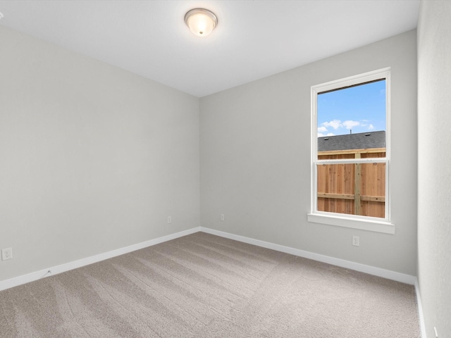 unfurnished room with carpet and baseboards