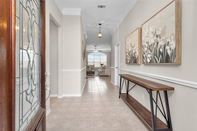 interior space featuring light tile patterned floors, visible vents, a ceiling fan, and ornamental molding