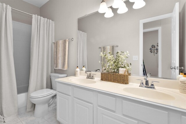 bathroom featuring double vanity, a sink, toilet, and shower / bath combo with shower curtain