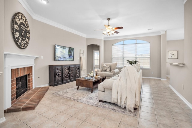 living room with a brick fireplace, light tile patterned flooring, visible vents, and crown molding