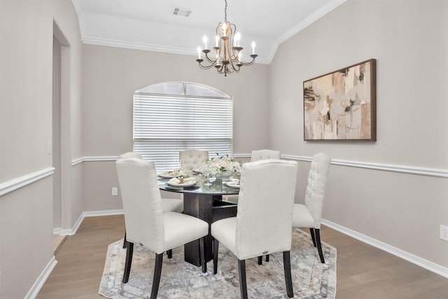 dining room featuring a chandelier, baseboards, visible vents, and light wood-style floors