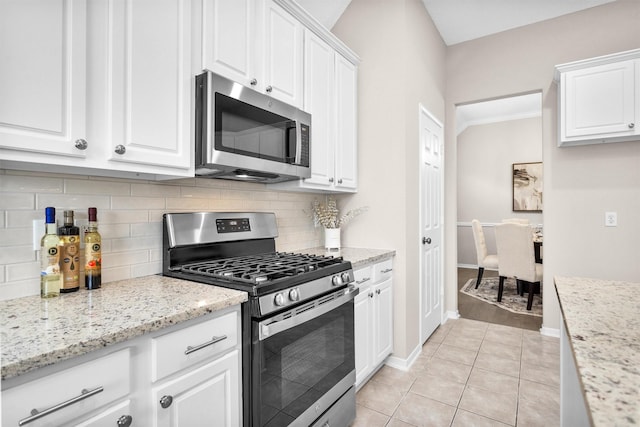 kitchen featuring stainless steel appliances, light tile patterned flooring, white cabinetry, and tasteful backsplash