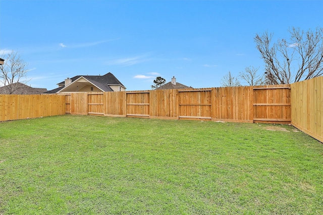 view of yard featuring a gate and a fenced backyard