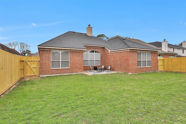 rear view of property with a fenced backyard, a gate, a lawn, and a patio