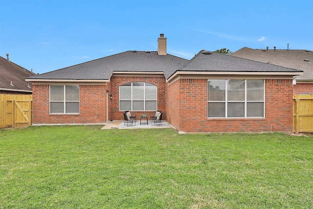 back of house with a patio, a shingled roof, brick siding, fence, and a chimney