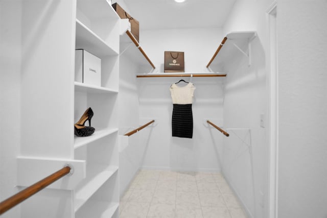 walk in closet with light tile patterned floors