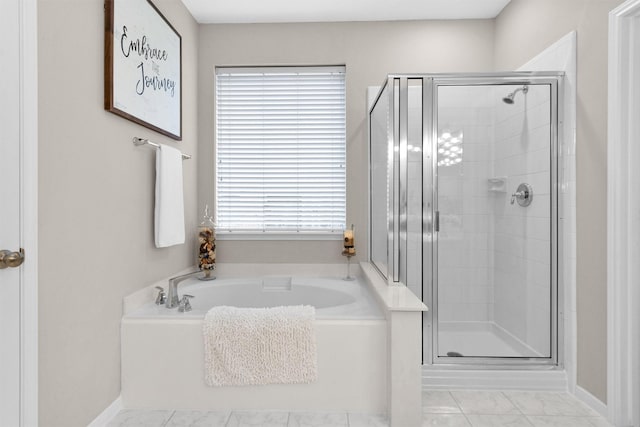 bathroom with a garden tub, a shower stall, and baseboards