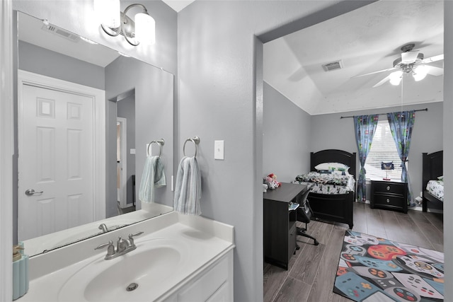 bathroom with visible vents, a ceiling fan, lofted ceiling, vanity, and wood finish floors