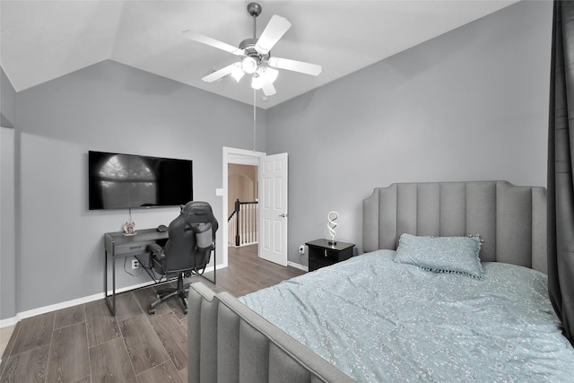 bedroom featuring lofted ceiling, dark wood finished floors, baseboards, and ceiling fan