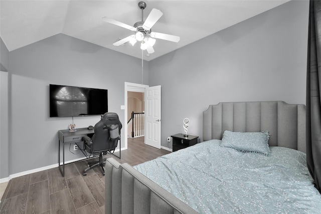 bedroom featuring a ceiling fan, baseboards, vaulted ceiling, and wood finished floors