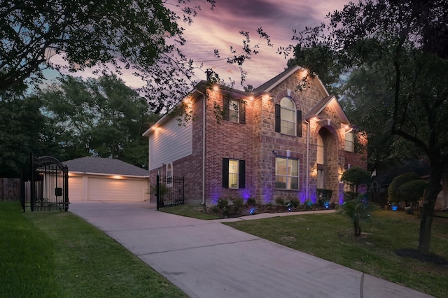 traditional home featuring a lawn, a gate, fence, and stone siding