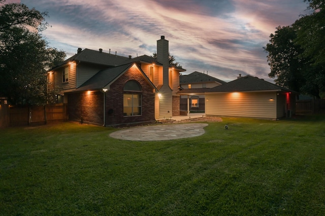 back of property with brick siding, fence, a chimney, and a patio
