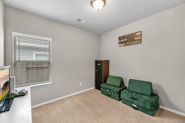 sitting room with baseboards, visible vents, and light colored carpet