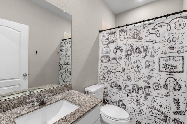 full bathroom featuring toilet, a textured wall, a shower with shower curtain, and vanity