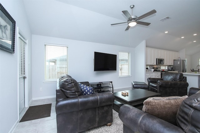 living room featuring light tile patterned floors, baseboards, visible vents, ceiling fan, and vaulted ceiling