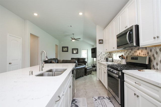 kitchen featuring visible vents, appliances with stainless steel finishes, open floor plan, white cabinets, and a sink