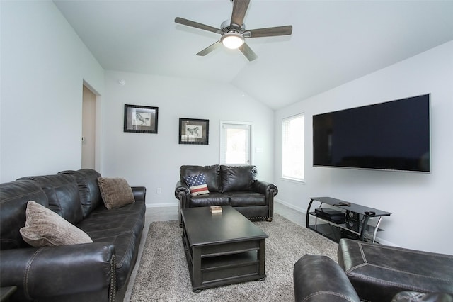 living room featuring lofted ceiling, ceiling fan, and baseboards