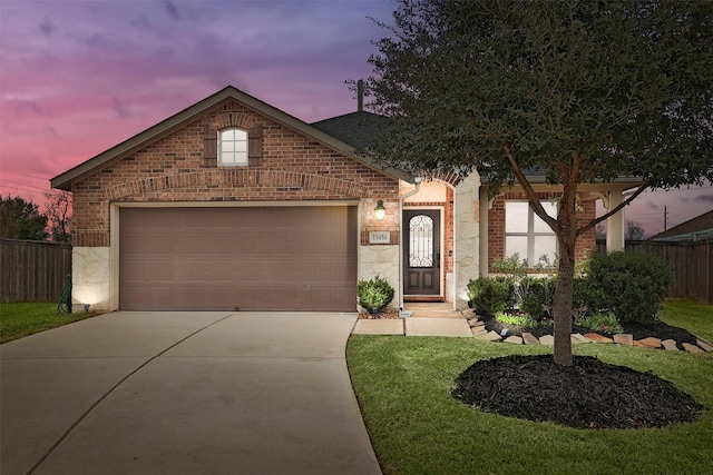 view of front of home featuring brick siding, fence, and driveway