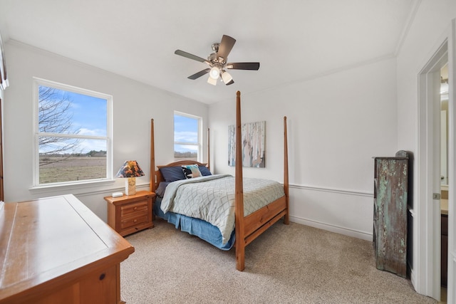 bedroom featuring light colored carpet, ceiling fan, and baseboards