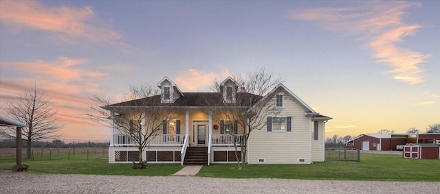 view of front facade featuring a shed, a porch, and a lawn