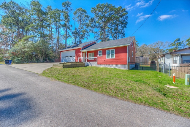 view of front of property featuring a garage, driveway, a front lawn, and fence