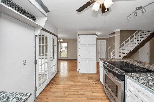 4900 Sandalwood Cir, Baytown, TX 77521 - kitchen with electric stove, dark stone countertops, white cabinetry, and light wood-style floors