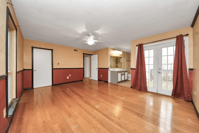 4900 Sandalwood Cir, Baytown, TX 77521 - unfurnished living room with light wood-type flooring, ceiling fan, visible vents, and french doors