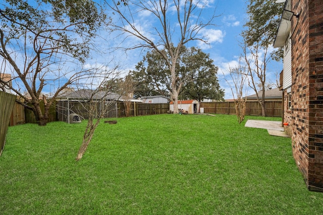 4900 Sandalwood Cir, Baytown, TX 77521 - view of yard featuring a patio area, a fenced backyard, a storage unit, and an outbuilding