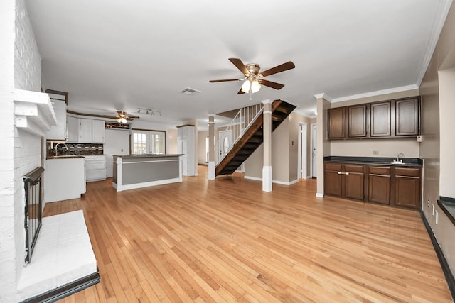 4900 Sandalwood Cir, Baytown, TX 77521 - unfurnished living room with visible vents, stairway, a sink, ceiling fan, and light wood-type flooring
