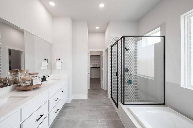 full bathroom with double vanity, recessed lighting, a stall shower, a sink, and a bath