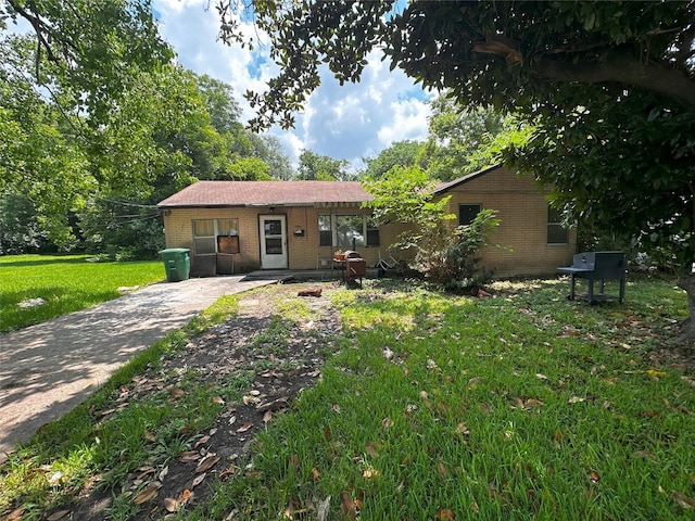 ranch-style house with a front lawn and brick siding