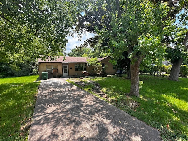 view of front facade featuring concrete driveway, brick siding, and a front lawn