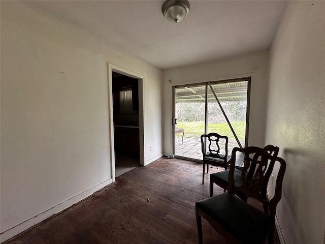 sitting room featuring baseboards and dark wood-type flooring