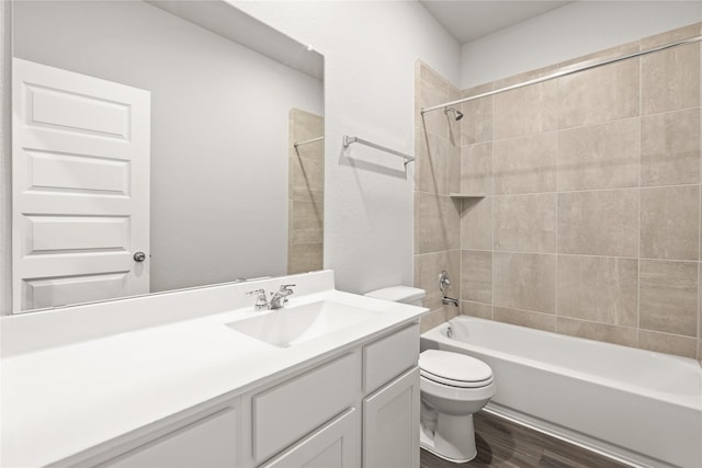 full bath featuring bathtub / shower combination, vanity, toilet, and wood finished floors