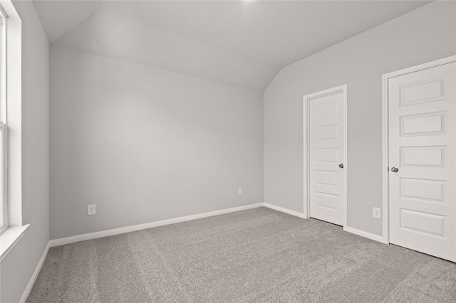 additional living space with vaulted ceiling, carpet floors, and baseboards