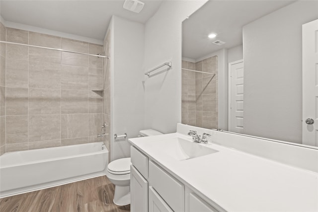 full bath featuring visible vents, toilet, wood finished floors, vanity, and shower / bathing tub combination