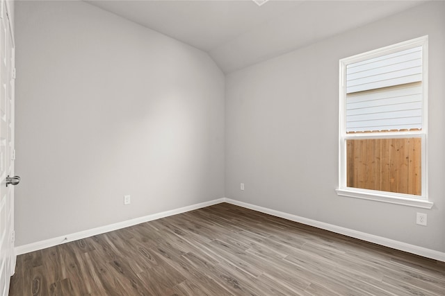 spare room with lofted ceiling, baseboards, and wood finished floors