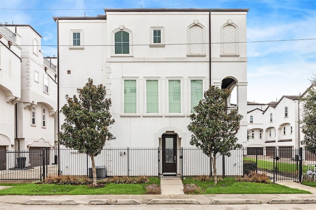 view of front of property featuring a fenced front yard, a gate, and stucco siding