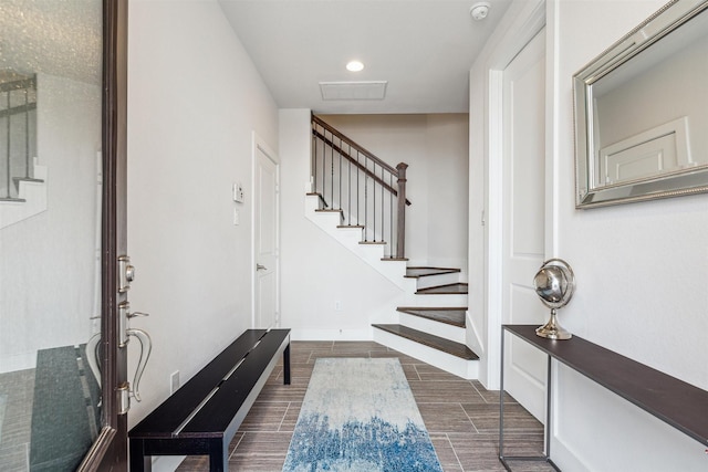 entryway with wood tiled floor, stairs, and recessed lighting