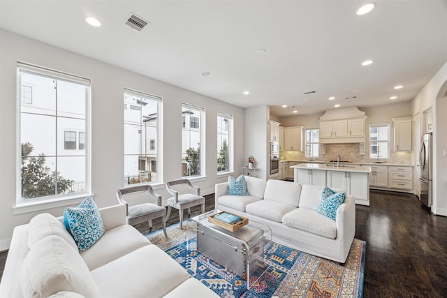 living area featuring dark wood-style floors, baseboards, visible vents, and recessed lighting