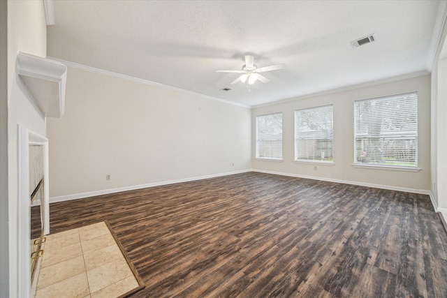 unfurnished living room with ornamental molding, dark wood-style flooring, visible vents, and baseboards