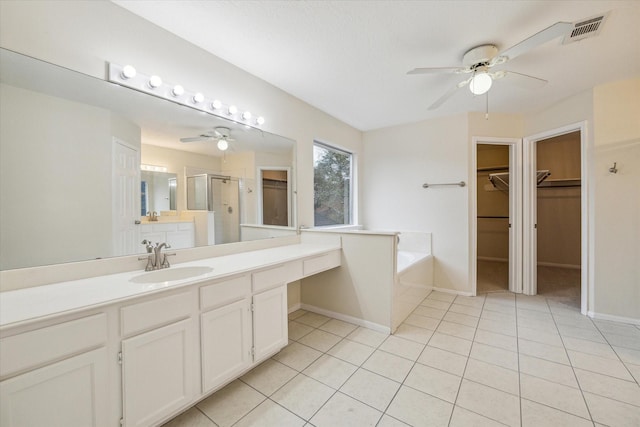 bathroom with visible vents, tile patterned floors, a garden tub, a walk in closet, and a shower stall