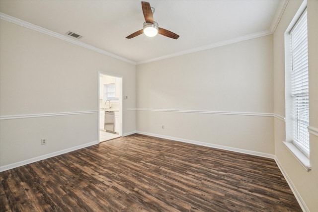 unfurnished room with dark wood-type flooring, visible vents, ornamental molding, and baseboards