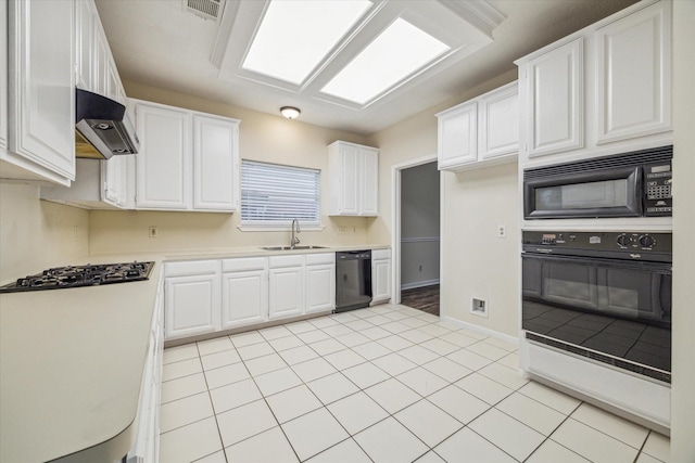 kitchen with black appliances, white cabinetry, light countertops, and a sink