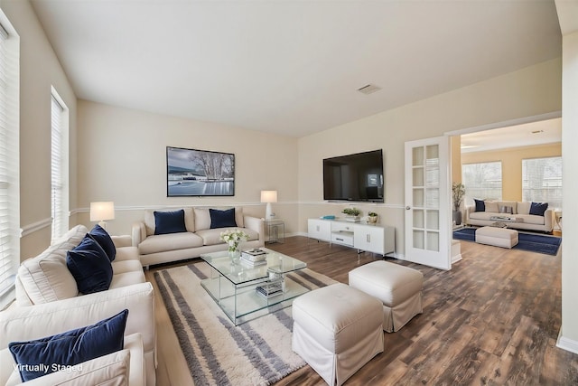 living area featuring dark wood-style floors, visible vents, and baseboards